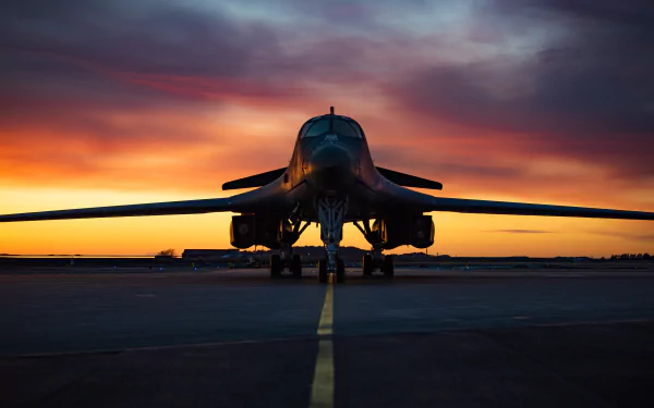 Rockwell B-1 Lancer bomber warplane on runway at sunset with dramatic sky, captured in stunning 4K Ultra HD for PC desktop wallpaper and background.