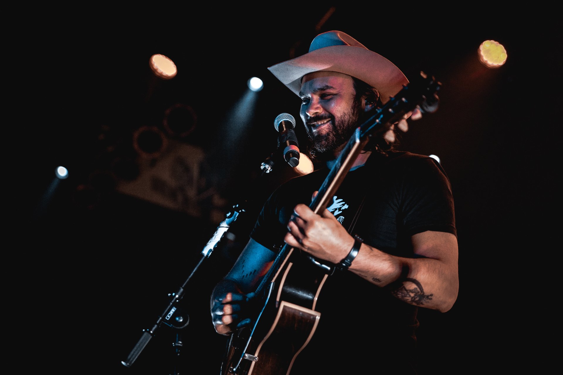 HD wallpaper featuring a performer with a guitar onstage, evoking the musical essence of Shakey Graves.