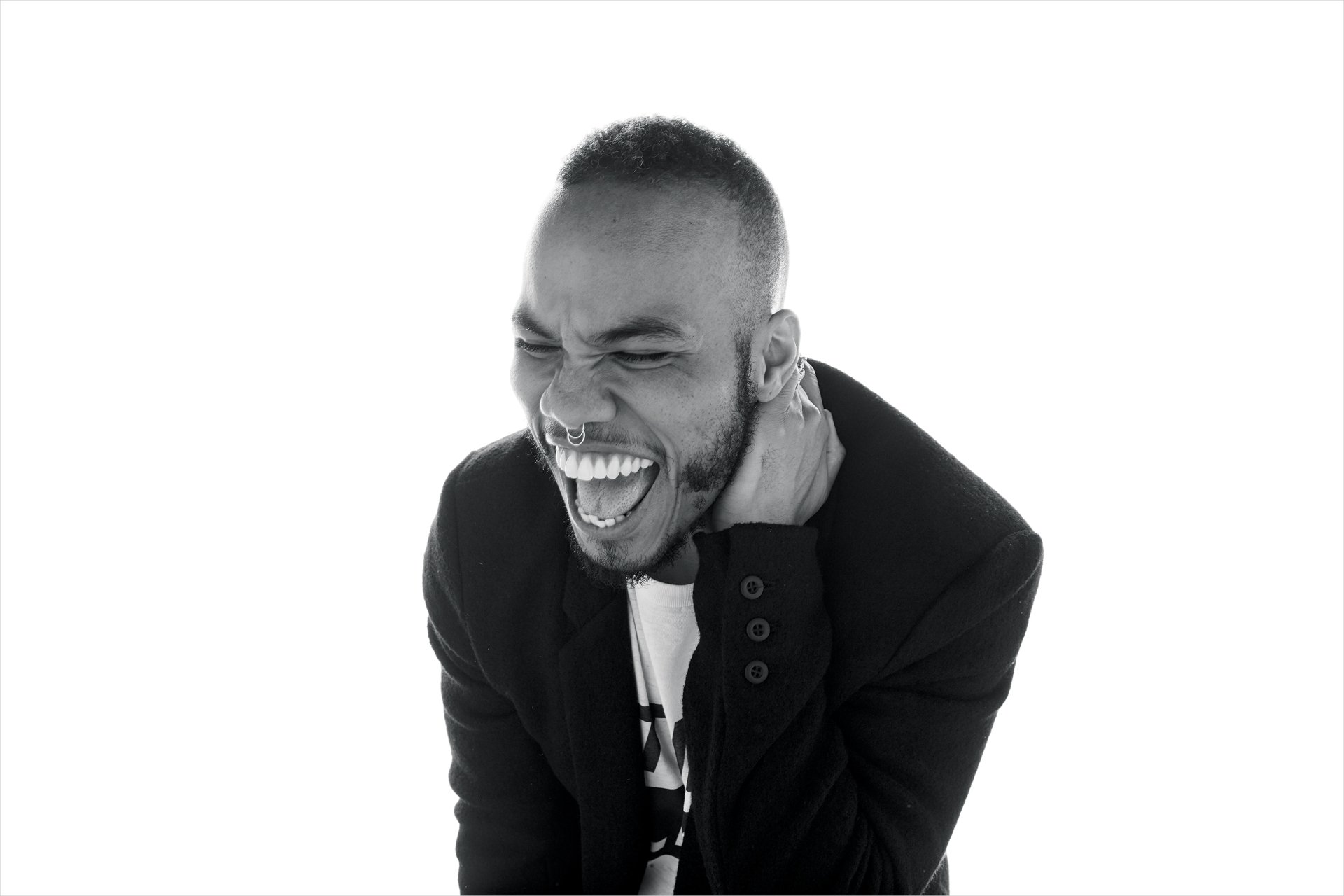 HD desktop wallpaper featuring Anderson .Paak in a black and white photo, laughing and touching his ear.
