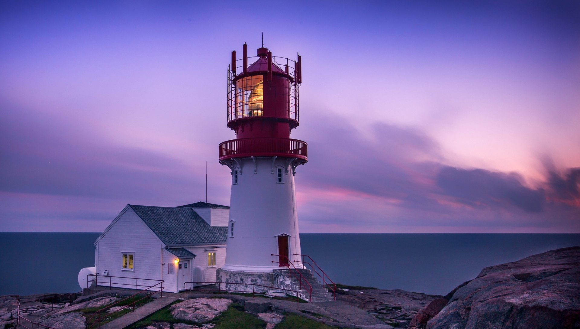 HD PC desktop wallpaper and background: man-made lighthouse on Norway's rocky coast at dusk, red lantern tower with adjoining keeper's house beneath a pastel sky.