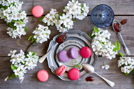 HD PC desktop wallpaper/background — food macaron arrangement: pink and purple macarons on vintage plates with spoons of jam and white spring blossoms on a rustic wooden table.