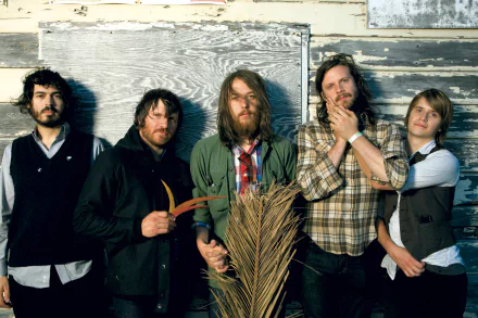 HD desktop wallpaper featuring the band Fleet Foxes, posing with a rustic backdrop.