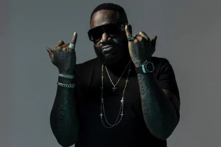 HD desktop wallpaper featuring a man with sunglasses, making hand gestures, adorned with jewelry, set against a gray background.