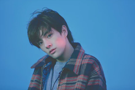 HD desktop wallpaper of an ENHYPEN member in a plaid jacket against a blue backdrop.