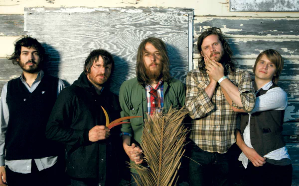 HD desktop wallpaper featuring the band Fleet Foxes, posing with a rustic backdrop.
