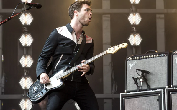 Royal Blood band member performing live with electric guitar in HD concert-themed desktop wallpaper background.