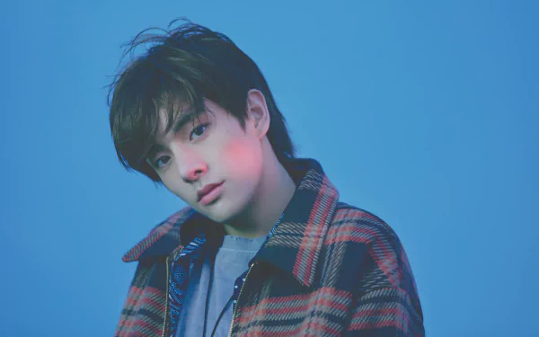 HD desktop wallpaper of an ENHYPEN member in a plaid jacket against a blue backdrop.