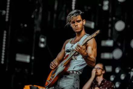 Musician from KALEO performing live on stage with an electric guitar, in a high-definition desktop wallpaper.