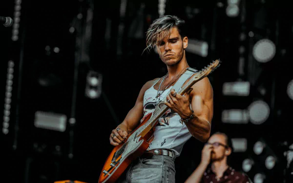 Musician from KALEO performing live on stage with an electric guitar, in a high-definition desktop wallpaper.