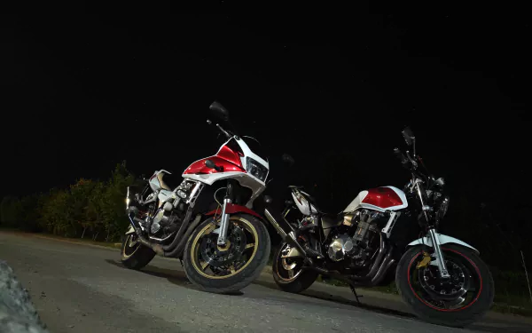 Two red-white Honda CB1300 motorcycles parked at night on a roadside — 4K Ultra HD PC desktop wallpaper and background featuring the Honda motorcycle vehicle.