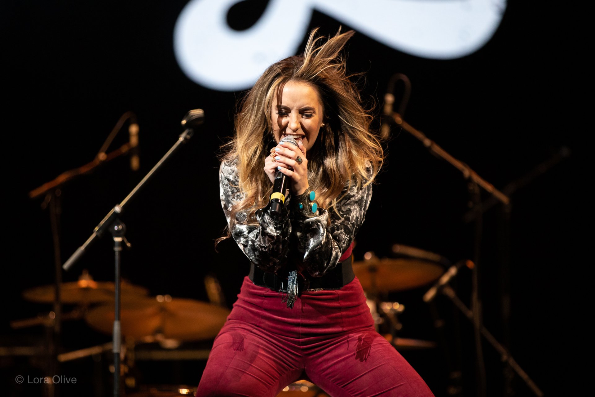 Singer performing energetically on stage, HD desktop wallpaper background.