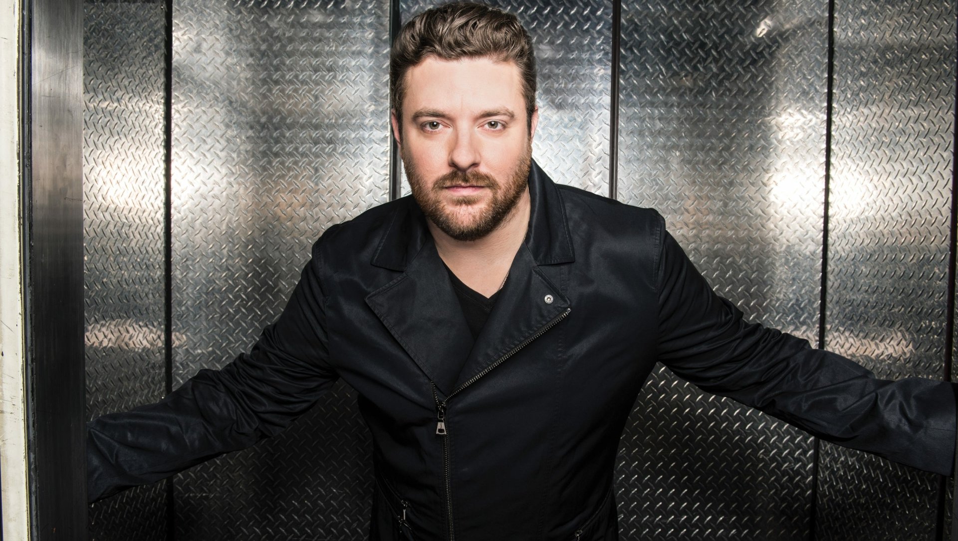 HD desktop wallpaper featuring a man in a black leather jacket posing against a metallic background, tagged as Chris Young.