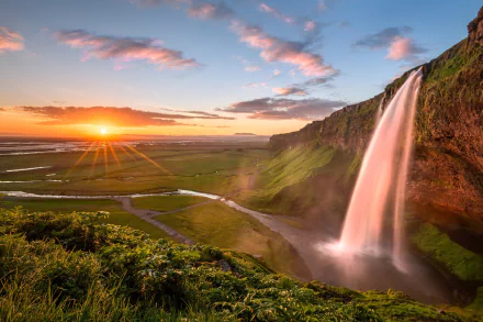 Sunrise over Seljalandsfoss, Iceland: cascading waterfall beside verdant cliffs and winding river under a colorful sky — HD landscape wallpaper