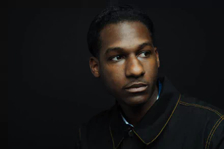 HD desktop wallpaper featuring a portrait of a man against a dark background, giving a contemplative look, tagged with Leon Bridges.