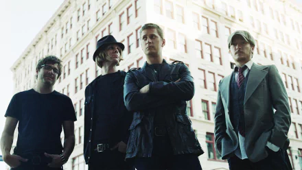 HD desktop wallpaper featuring Matchbox Twenty band members posing in front of a city building background.