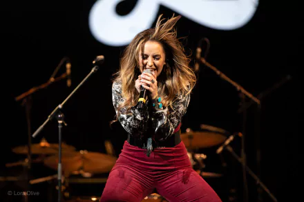 Singer performing energetically on stage, HD desktop wallpaper background.