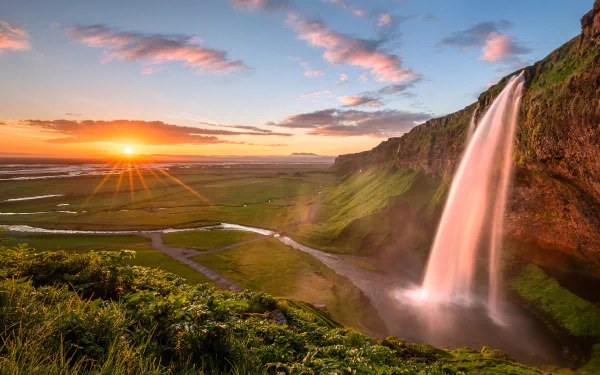 Sunrise over Seljalandsfoss, Iceland: cascading waterfall beside verdant cliffs and winding river under a colorful sky — HD landscape wallpaper