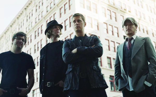 HD desktop wallpaper featuring Matchbox Twenty band members posing in front of a city building background.