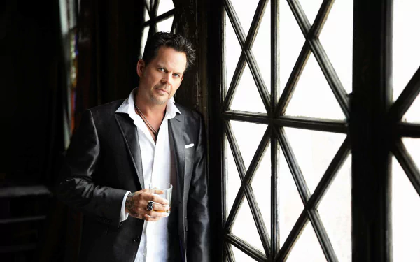 HD desktop wallpaper featuring a man in a black suit standing by a window, exuding a confident aura, suitable as a background image.