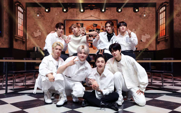 HD PC desktop wallpaper featuring the K-pop boy band Stray Kids posing together in a stylish indoor setting with warm lighting and a checkered floor.