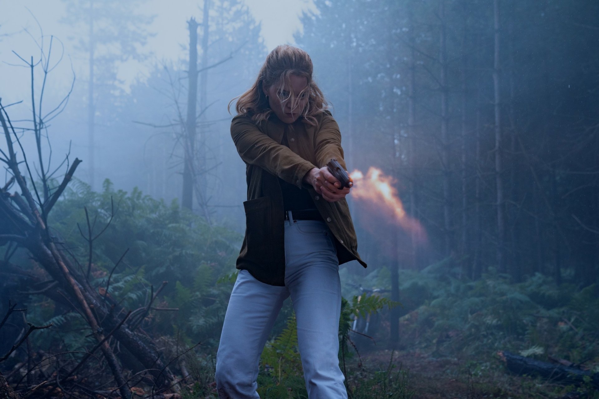 Madeleine Swann, played by Léa Seydoux, fires a handgun in a misty forest scene from the movie No Time to Die, featured as an HD PC desktop wallpaper.