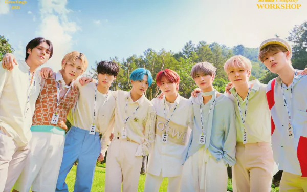 A vibrant HD wallpaper featuring the K-pop group ATEEZ, showcasing all eight members in stylish outfits against a bright outdoor backdrop with trees and blue sky.