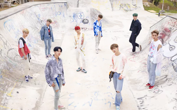 ATEEZ band members posing casually in a graffiti-covered skate park, offering a stylish and youthful vibe for HD desktop wallpaper and background.
