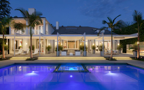 HD desktop wallpaper showcasing a luxurious man-made pool in front of a modern villa at dusk, framed by palm trees and ambient lighting.