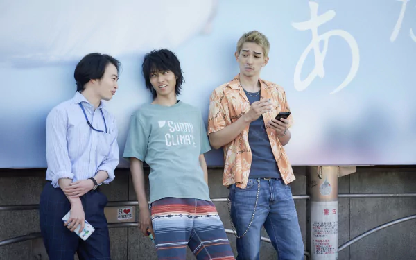 4K Ultra HD PC desktop wallpaper for the TV show Alice in Borderland: three young men in casual summer clothes leaning against a wall beneath a pale blue billboard.