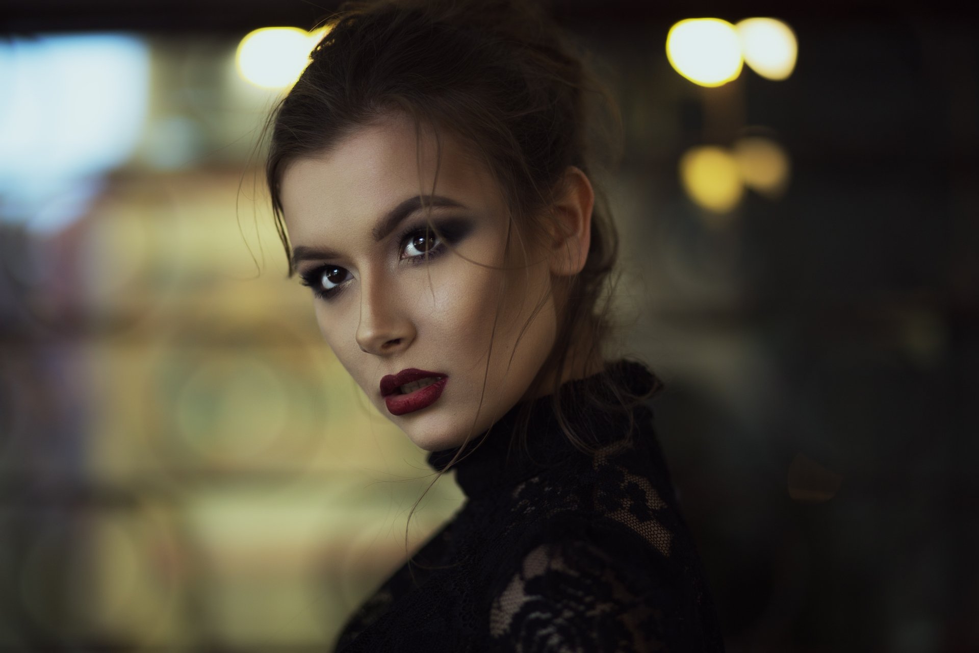 4K Ultra HD PC desktop wallpaper of a woman model with brown eyes and dark lipstick, wearing black lace against warm bokeh lights.