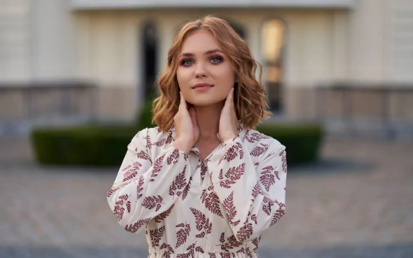 4K Ultra HD PC desktop wallpaper: portrait of a redhead woman model in a leaf-print blouse with wavy hair bathed in soft evening outdoor light.