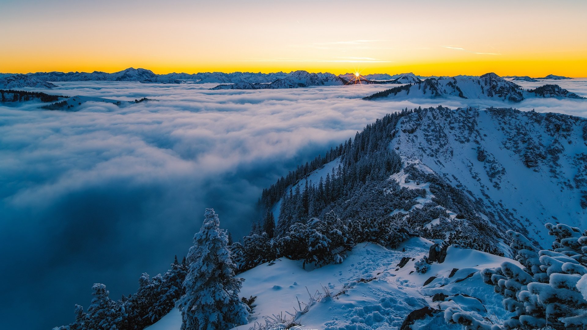 4K Ultra HD PC desktop wallpaper and background: winter mountain ridge above a sea of clouds and fog at sunrise, snow-dusted trees and distant peaks.
