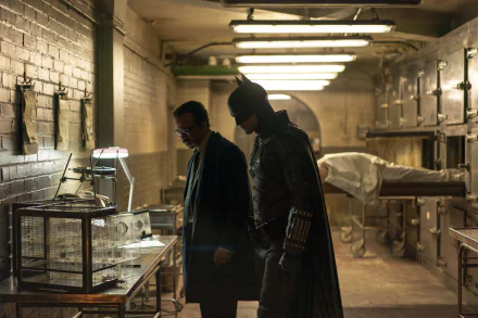 HD movie wallpaper featuring Robert Pattinson as Batman in his Batsuit alongside Jeffrey Wright as Commissioner Gordon in a dimly lit, industrial setting from The Batman.