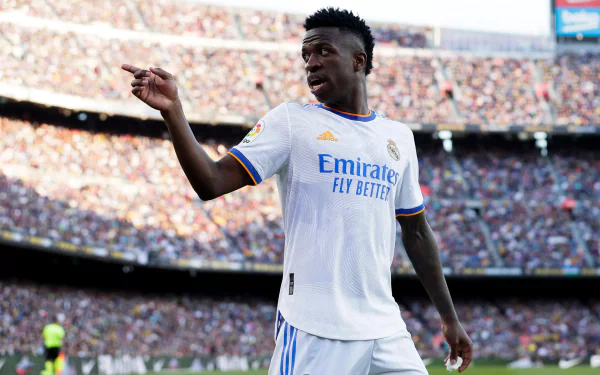 2K Quad HD PC desktop wallpaper of a Real Madrid forward in white kit pointing to the crowd in a dynamic sports stadium shot.