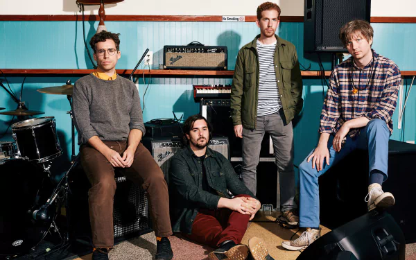 HD desktop wallpaper featuring four members of a band with musical instruments in the background, tagged with Parquet Courts.