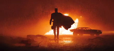 HD desktop wallpaper and background featuring a striking scene from the movie The Batman. The silhouette of Batman is highlighted against a fiery background, creating a dramatic and intense visual.