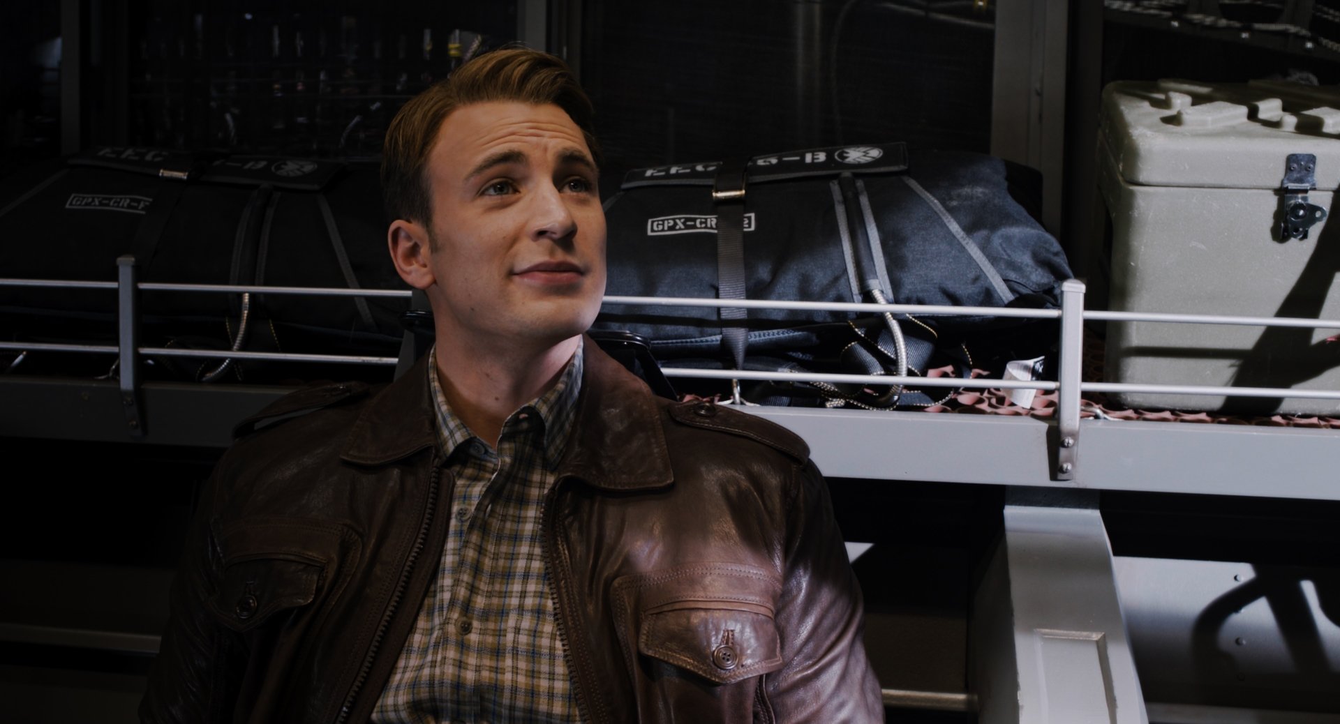 2K Quad HD PC wallpaper: cinematic movie portrait of a WWII-era hero in a leather jacket inside an aircraft hangar, Avengers-themed background.