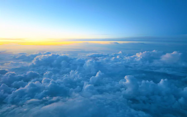 4K Ultra HD PC desktop wallpaper: serene sea of clouds stretching to the horizon at sunrise, soft blue sky and layered clouds.