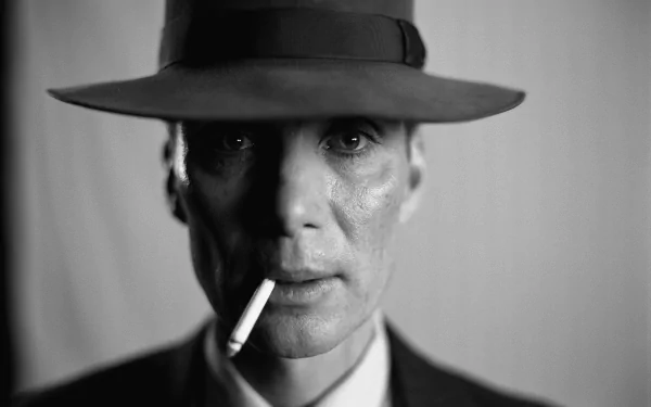 8K Ultra HD movie-style desktop wallpaper: black-and-white close-up of a fedora-clad man smoking, cinematic Oppenheimer-era atmosphere.