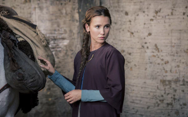 A 4K Ultra HD desktop wallpaper featuring a scene from the TV show The Last Kingdom, showing a woman in period attire adjusting a saddle against a rustic backdrop.