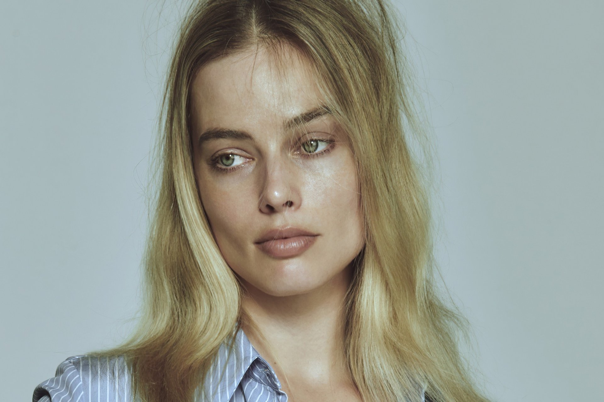 HD desktop wallpaper featuring a close-up portrait of celebrity Margot Robbie with soft lighting and a neutral background.
