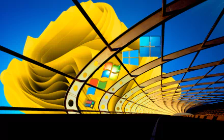 Technology-themed HD PC desktop wallpaper: a Windows 11 logo woven into a yellow, rose-like spiral tunnel against a vivid blue sky background.