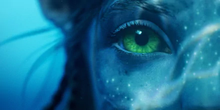 Close-up of a vibrant green eye of a Na'vi character from the movie Avatar: The Way of Water, featured as an HD PC desktop wallpaper background.