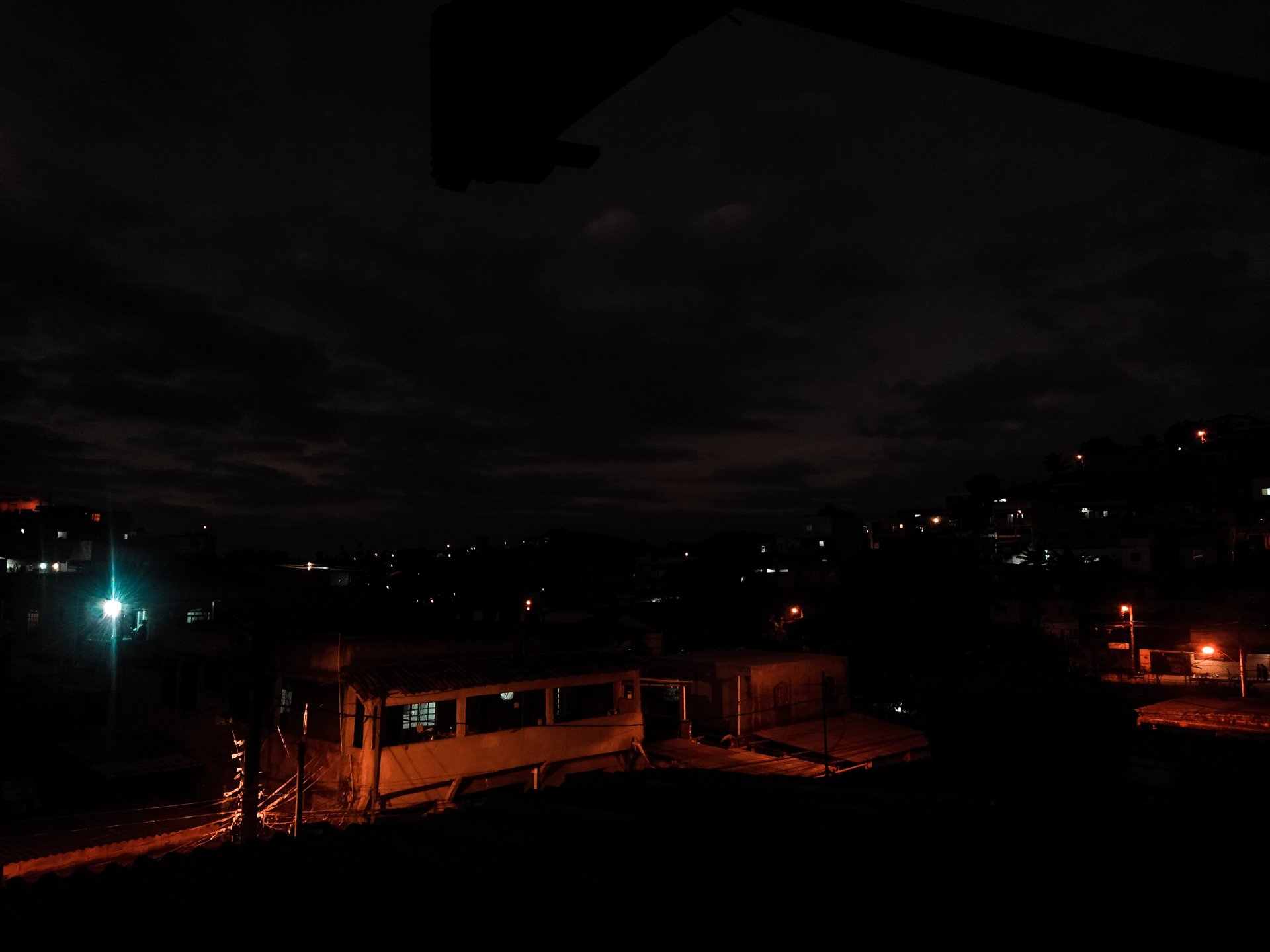 Night 4K Ultra HD PC desktop wallpaper and background: dimly lit urban street, scattered city lights and orange streetlamps beneath a cloudy night sky.