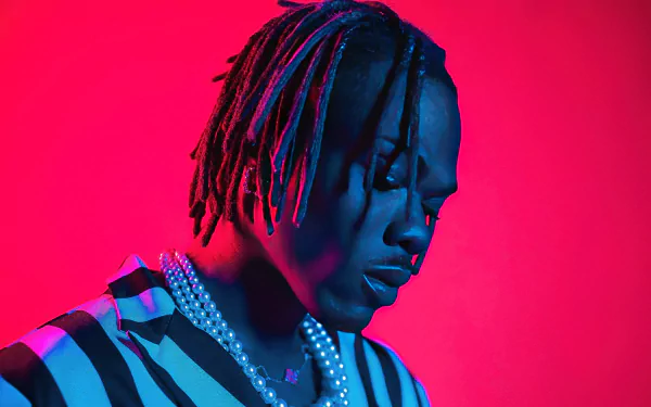High-definition desktop wallpaper of a man with braided hair, wearing striped attire, against a vibrant red and blue background, tagged with CKay.