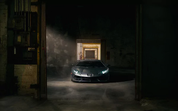 Front view of a Lamborghini Aventador SVJ with headlights piercing a dim industrial garage — 4K Ultra HD PC desktop wallpaper background.