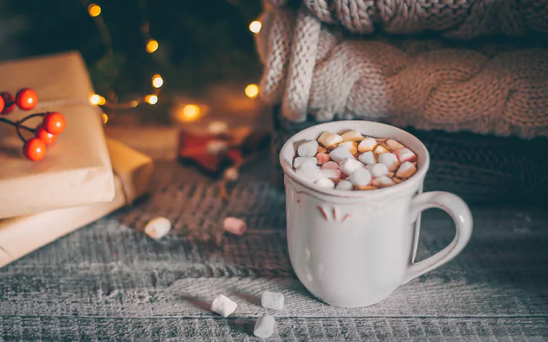 A cozy winter-themed HD desktop wallpaper featuring a tempting cup of hot chocolate.