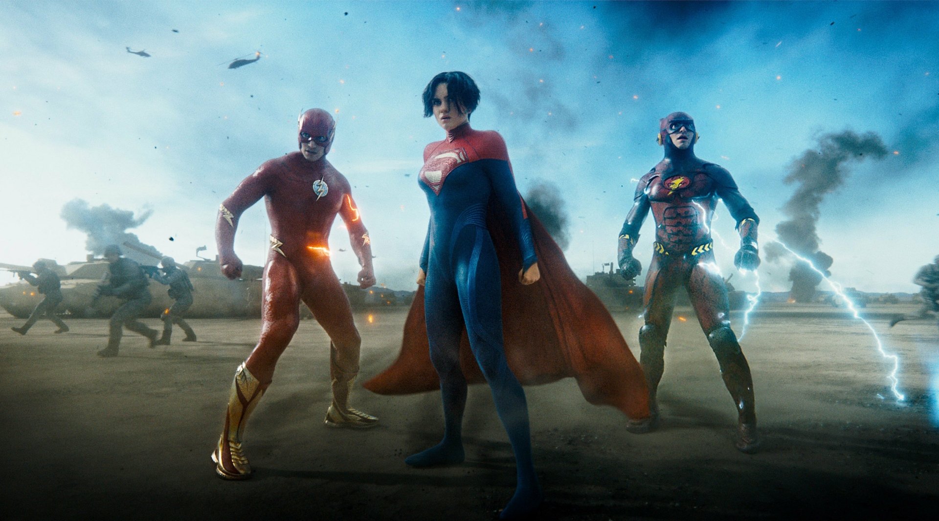 HD PC desktop wallpaper featuring The Flash (2023) alongside Superman and Batman, set in a dramatic battle scene with a smoky, blue-toned background.