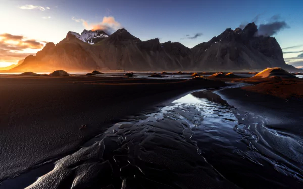 5K Ultra HD PC desktop wallpaper and background: Vestrahorn nature scene — jagged mountains at sunset above a black sand beach with reflective tidal pools and a glowing, dramatic sky.
