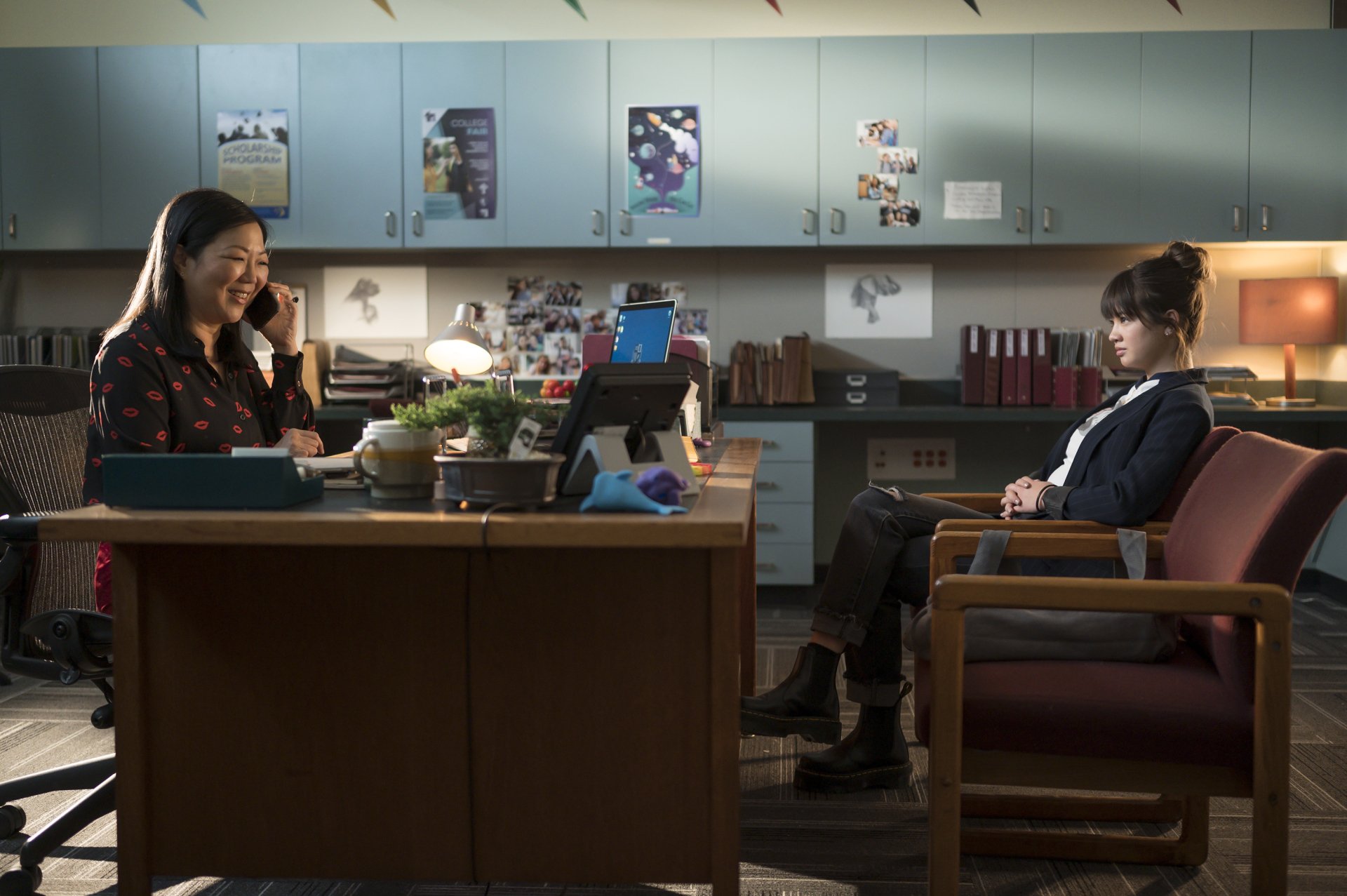 HD desktop wallpaper and background from Prom Pact depicting two characters in an office setting, one on the phone and the other seated across.